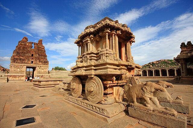 Stone Chariot at Vittala Temple surrounded by ancient ruins in Hampi, Karnataka, a UNESCO World Heritage Site.