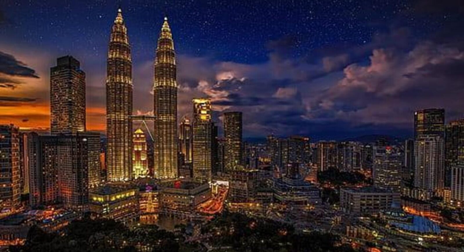 Malaysia Tour Package: Petronas Twin Towers illuminated at night in Kuala Lumpur